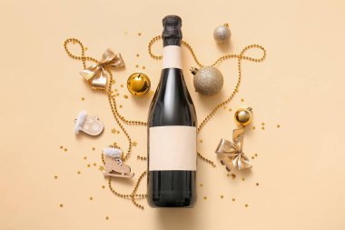 Bir şişe şampanya, Noel süslemeleri ve sarı arka planda konfeti.