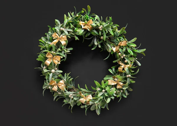 Christmas mistletoe wreath with bows on black background
