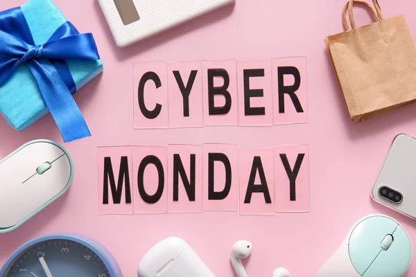 stock image Text CYBER MONDAY made of letters, gadgets and gift box on pink background