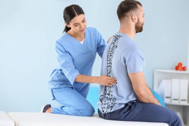 Rehabilitasyon merkezinde erkek hastayla çalışan fizyoterapist.