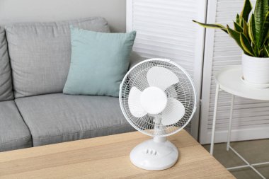 Modern elektrikli vantilatör oturma odasındaki masada.