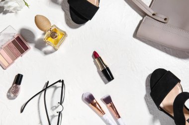 Kozmetik ürünleri, bayan ayakkabıları ve hafif arka planda aksesuarları olan kompozisyon