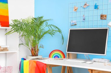 Ofiste bilgisayar monitörü ve oyuncak gökkuşağı olan işyeri