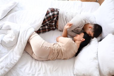 Yatak odasında uyuyan genç bir çift.