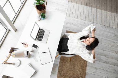 Genç Asyalı kadın merkez ofiste dinleniyor.