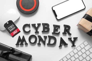 Pazartesi günü siyah harflerden, cihazlardan ve açık arkaplanda hediye kutularından oluşan CyBER metni.