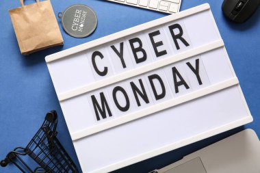 Pazartesi günü CYBER yazılı pano, mavi arka planda küçük alışveriş arabası ve çanta, yakın plan