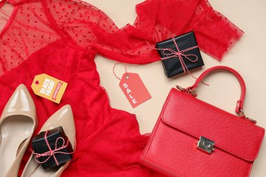 Şık bir kadın elbisesi, el çantası ve renkli arka planda hediye kutuları olan kompozisyon, yakın plan. Kara Cuma indirimi