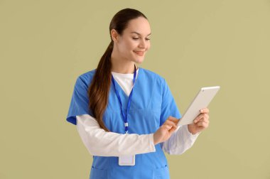 Yeşil arka planda tablet bilgisayarı olan kadın stajyer.