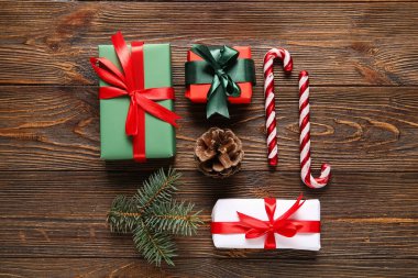 Noel ağacı dallı hediye kutuları ve tahta arka planda şeker kamışları.