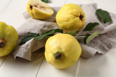 Tatlı olgun ayva ve yapraklar beyaz ahşap arka planda