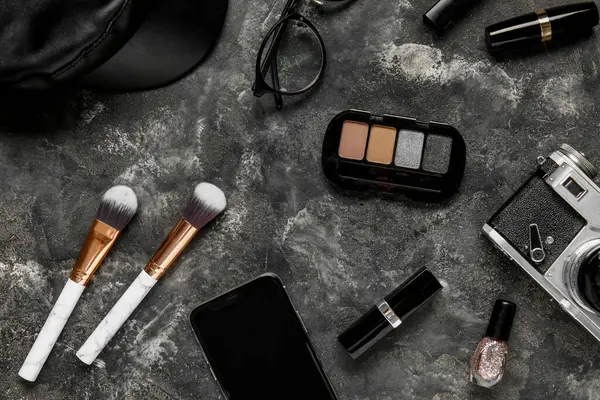 Composition with cosmetics, accessories and mobile phone on grunge background