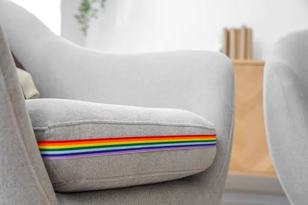 Armchair with rainbow ribbon in living room, closeup