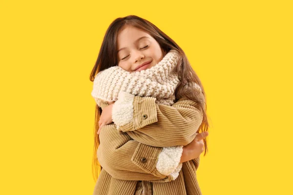 黄色の背景に冬の服を着た少女 — ストック写真