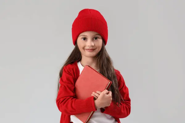 軽い背景の本と冬の服の小さな女の子 — ストック写真