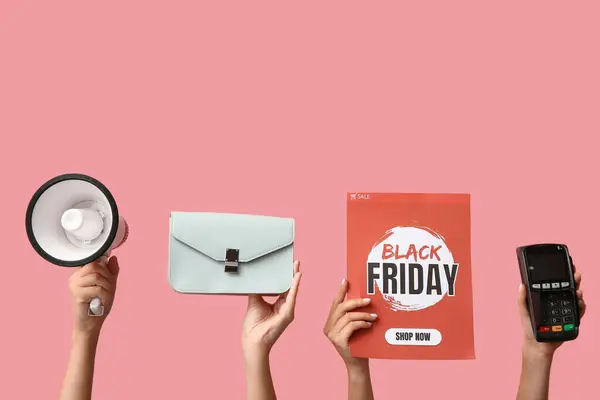 Female hands holding poster with text BLACK FRIDAY, megaphone, purse and payment terminal on pink background