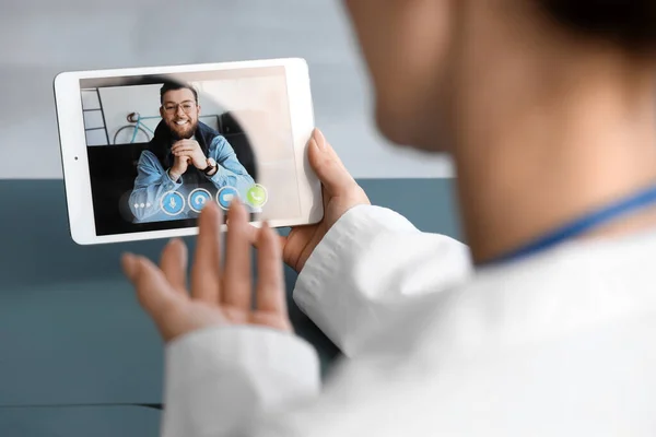 Female doctor video chatting with patient in office, closeup