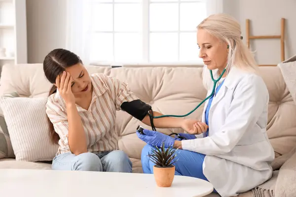 Female Doctor Measuring Blood Pressure Patient Home — Stock Photo, Image