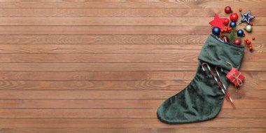 Ahşap arka planda dekorlu Noel çorabı ve metin için yer var.