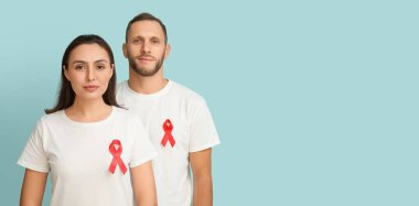 Açık mavi arkaplanda kırmızı farkındalık kurdeleleri olan genç bir çift. Dünya AIDS Günü Afişi