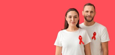 Kırmızı arka planda farkındalık kurdeleleri olan genç bir çift ve mesaj için yeri var. Dünya AIDS Günü Afişi