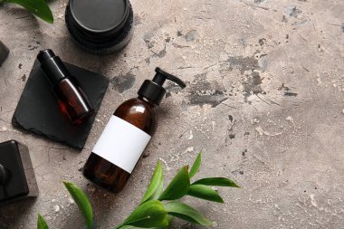 Gri arka planda şampuan şişeleri ve kozmetik ürünleri