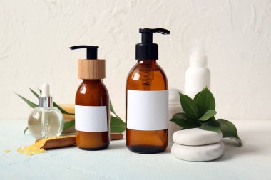 Beyaz arka planda şampuan, spa taşları, deniz tuzu ve kozmetik ürünleri.