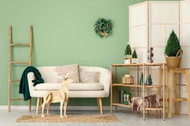 Noel için dekore edilmiş oturma odasının içinde kanepe ve raf ünitesi var.