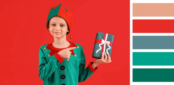 Netter Kleiner Junge Elfenkostüm Zeigt Auf Weihnachtsgeschenk Auf Rotem Hintergrund — Stockfoto