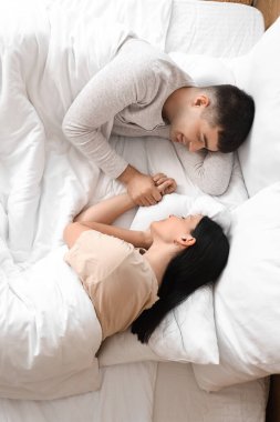 Yatak odasında uyuyan genç bir çift.
