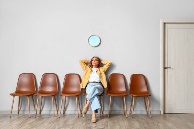 Olgun kadın odada sırasını bekliyor.