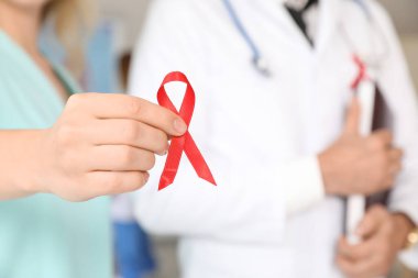 Klinikte kırmızı kurdeleli doktorlar, yakın plan. Dünya AIDS Günü konsepti