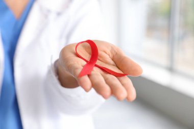 Klinikte kırmızı kurdeleli kadın doktor, yakın plan. Dünya AIDS Günü konsepti