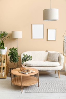 Beyaz kanepesi, kahve masası ve çiçekleri olan oturma odasının içinde.