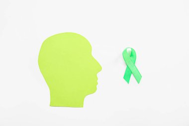 Beyaz arka planda yeşil farkındalık kurdelesi olan kağıt insan kafası. Ruh Sağlığı Günü