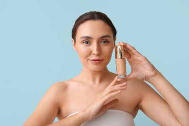 Mavi arka planda makyajlı genç bir kadın, yakın plan.