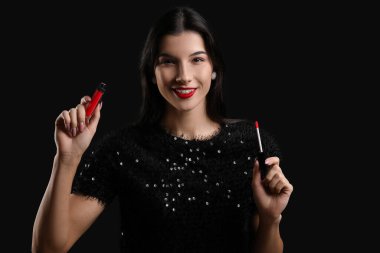 Siyah arka planda kırmızı ruju olan güzel bir genç kadın.