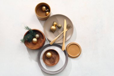 Beyaz arka planda Noel topları ve köknar dallarıyla güzel bir masa.