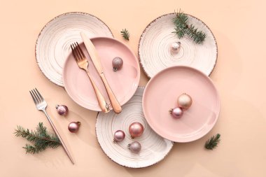 Noel topları ve bej arka planda köknar dallarıyla güzel bir masa.