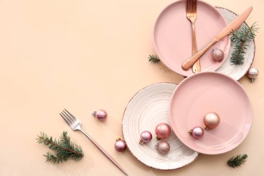 Noel topları ve bej arka planda köknar dallarıyla güzel bir masa.