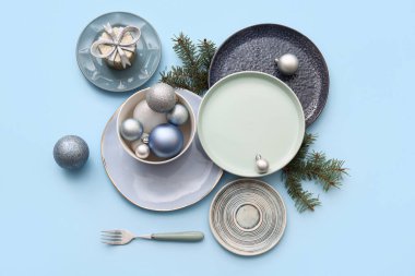 Noel baloları, köknar dalları ve mavi arka planda hediye kutusu olan güzel bir masa.