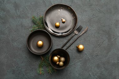 Noel baloları ve koyu arkaplanda köknar dalları olan güzel bir masa.