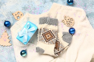 Sıcak çorapları ve mavi arka planda Noel dekoru olan güzel bir kompozisyon.