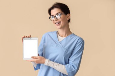 Bej arka planda tablet bilgisayarı olan bir kadın stajyer.