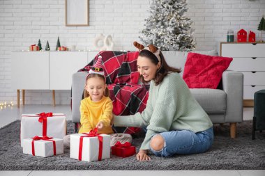 Küçük kızı ve evde Noel hediyeleri olan genç bir anne.