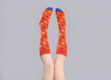 Gri arka planda çoraplı genç kadın bacakları