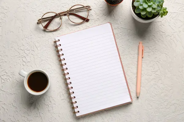 stock image Notebook with eyeglasses and cup of tasty coffee on white background