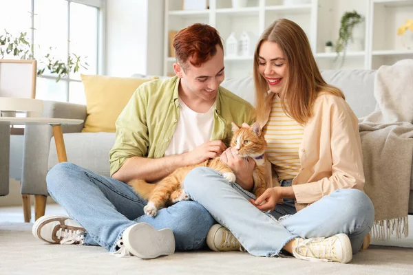 Young couple with cute cat sitting at home