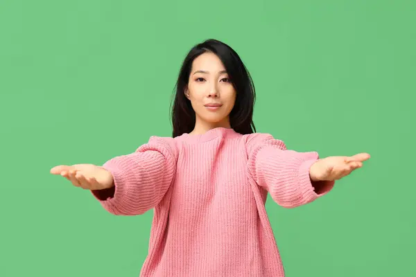 緑の背景に抱擁のための腕を開く若いアジアの女性 — ストック写真