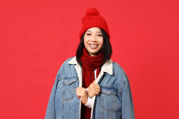 赤い背景の冬の服の若いアジアの女性 — ストック写真